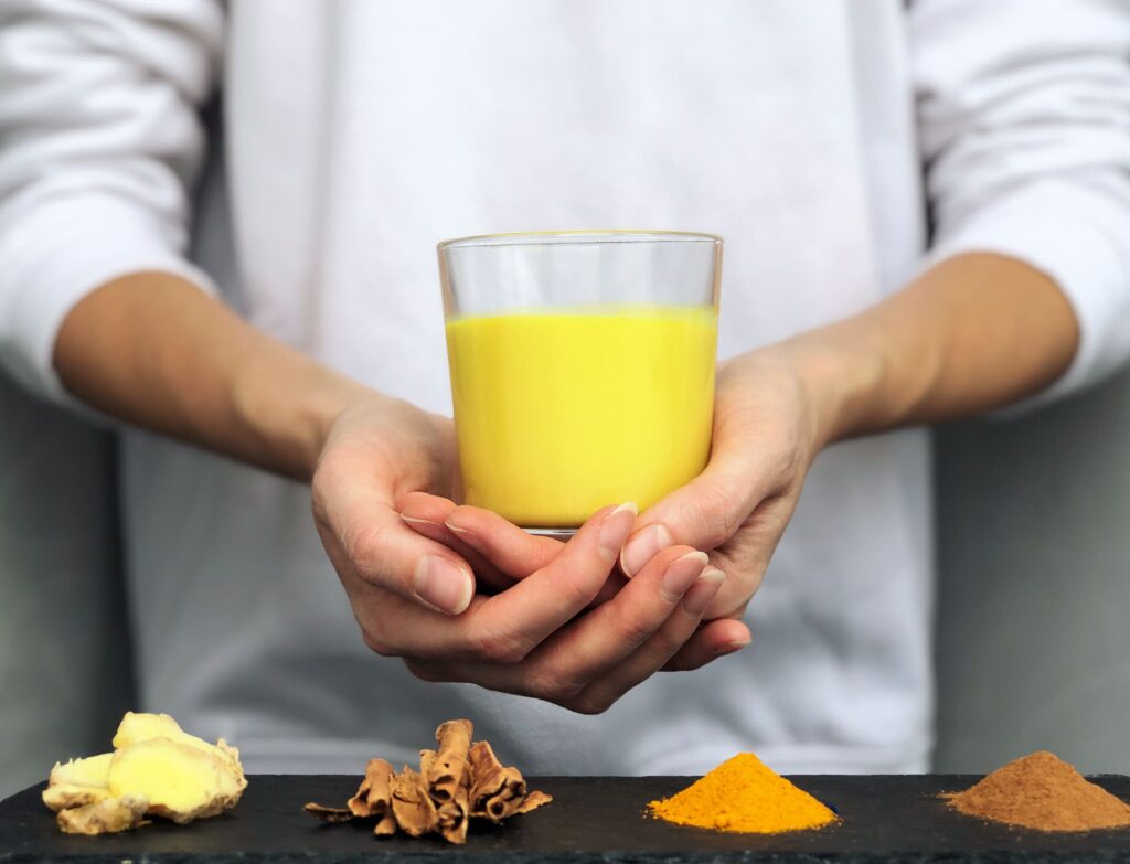 hands-holding-a-glass-of-golden-milk-turmeric-mil-2025-01-07-18-19-59-utc